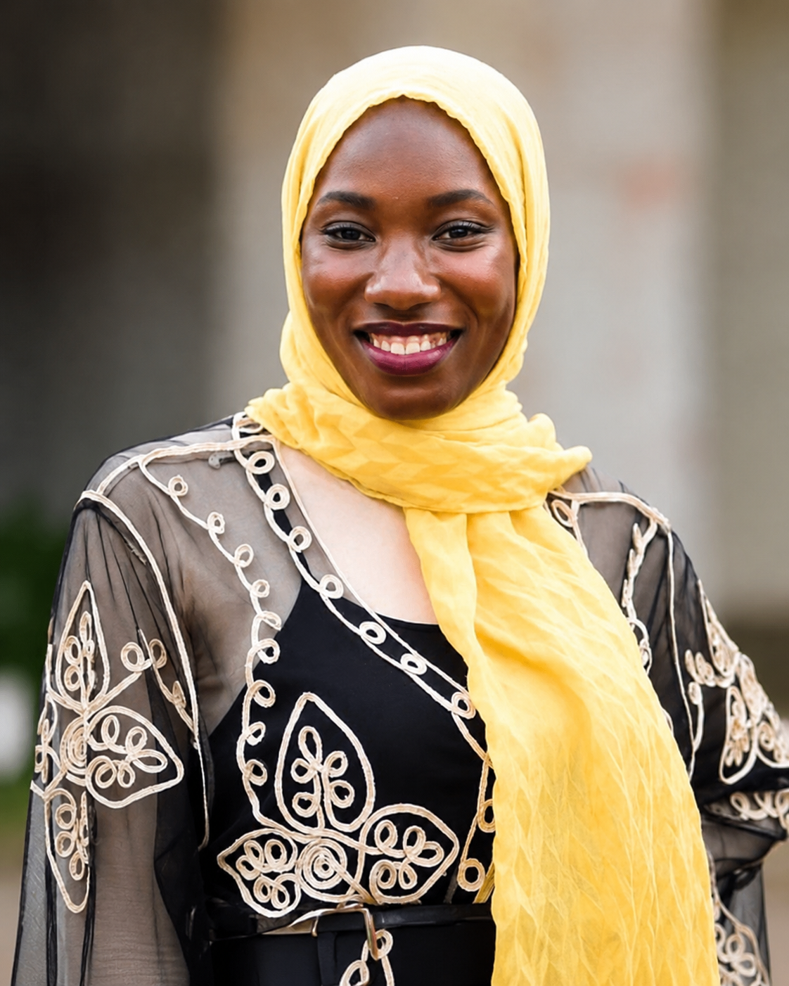 Sona T. Sesay, professional portrait in formal business attire, composed and confident, warm institutional lighting